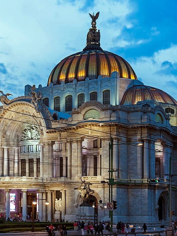 The golden domes of Mexico City's Palacio de Bellas Artes at dusk